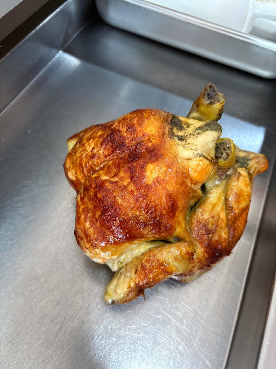 Pollo a l'ast recién asado entero con piel dorada crujiente en Rostisseria MARFA